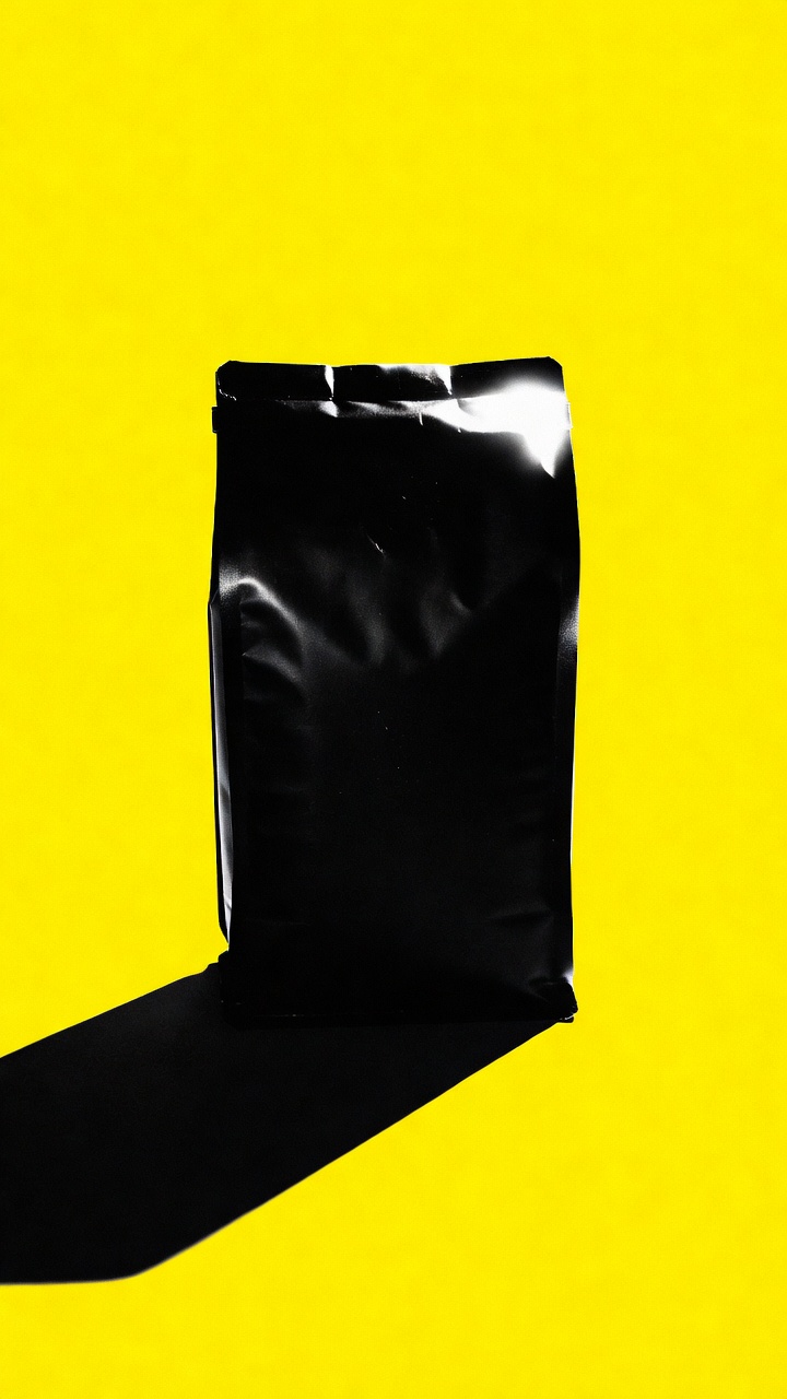 Brutalist productfoto: zwarte koffiezak op felgeel